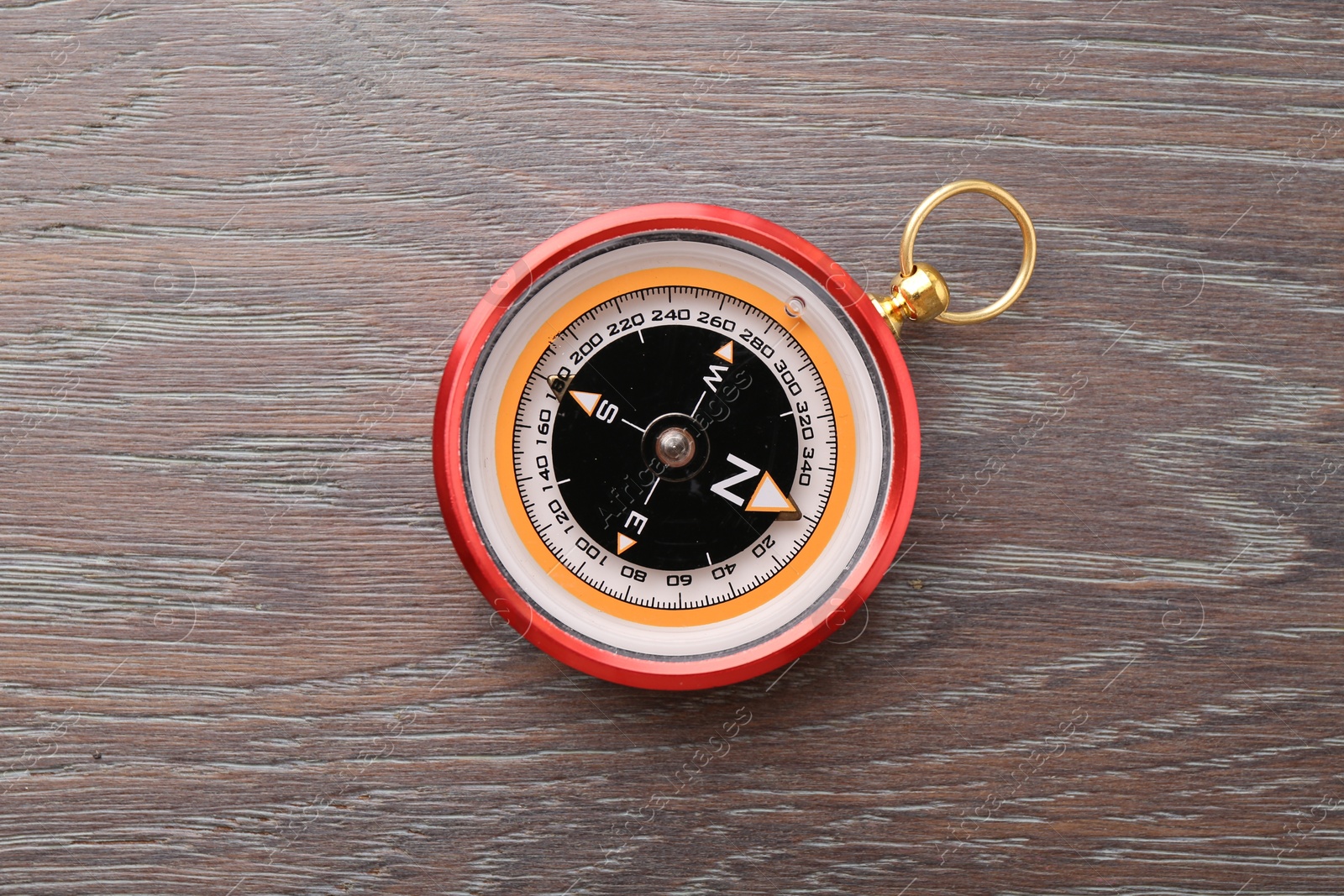 Photo of One compass on wooden table, top view