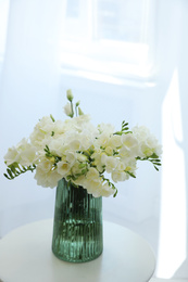 Beautiful bouquet with white freesia flowers on table indoors