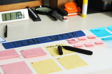 Business process planning and optimization. Workplace with colorful paper notes and other stationery on white wooden table