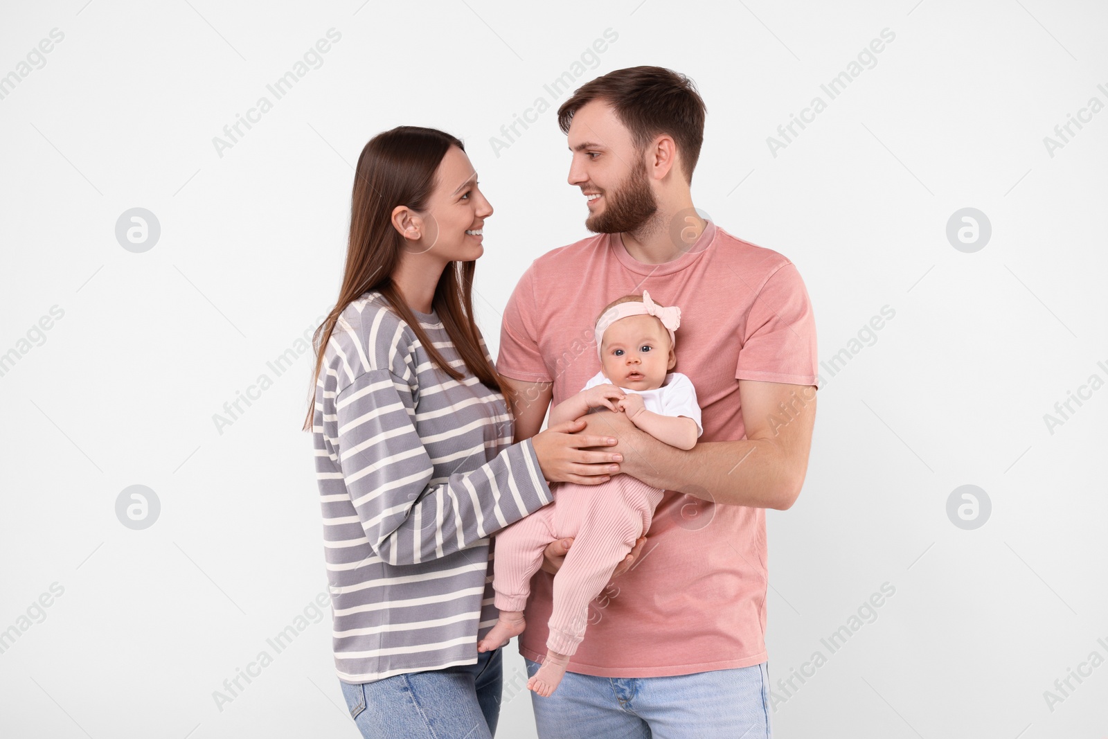 Photo of Happy family. Parents with their cute baby on light background