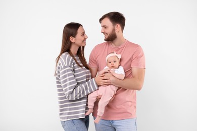 Photo of Happy family. Parents with their cute baby on light background