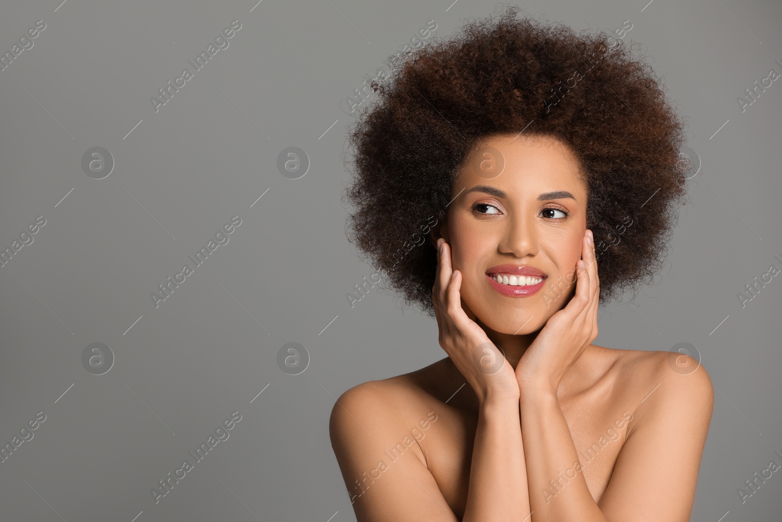 Photo of Portrait of beautiful young woman with glamorous makeup on grey background. Space for text