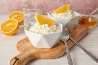 Creamy rice pudding with orange served on wooden table