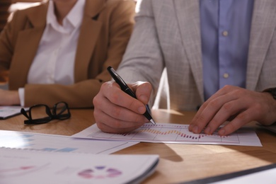 Photo of Business people working with documents at table in office, closeup. Investment analysis