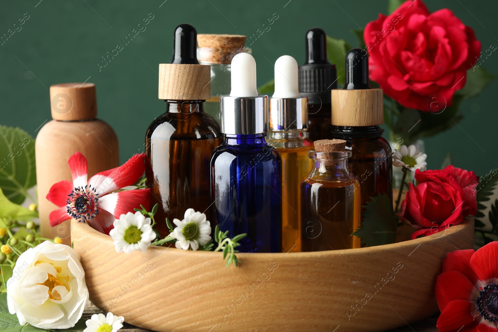 Photo of Aromatherapy. Different essential oils and flowers on table