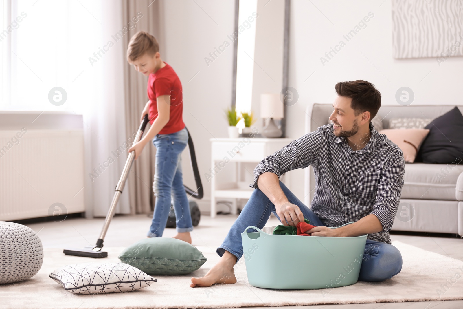 Photo of Little boy and his dad cleaning their house together