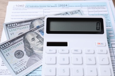 Photo of Tax accounting. Calculator, document and dollar banknotes on table, closeup