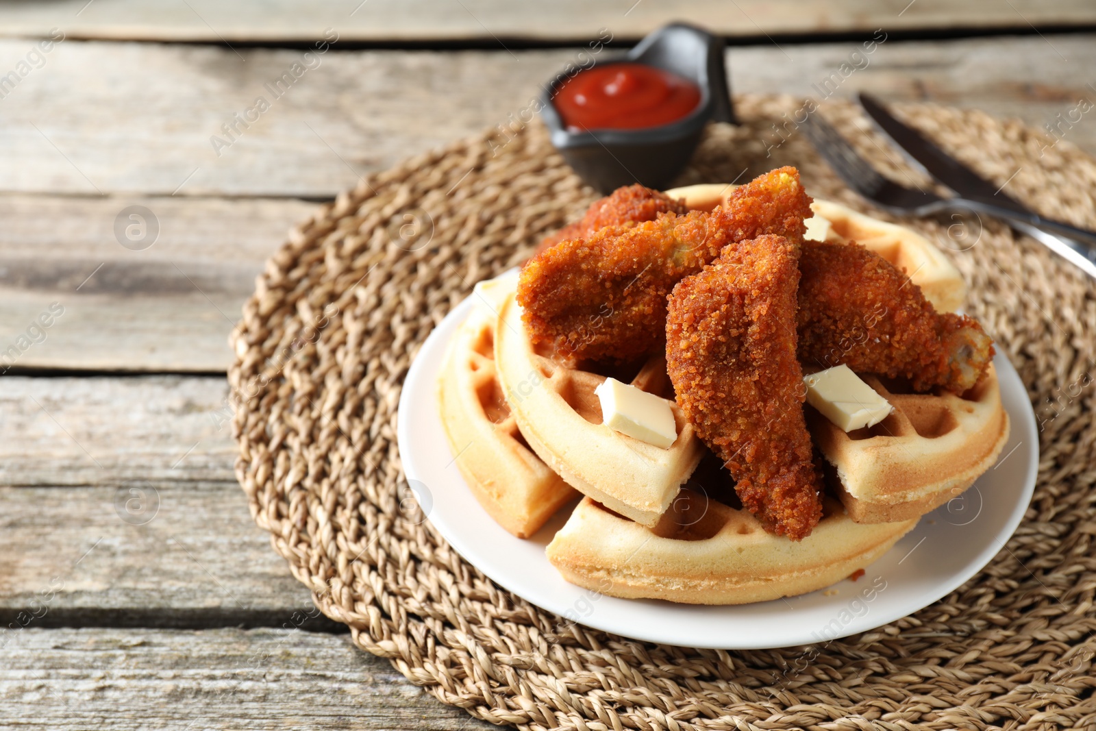 Photo of Delicious Belgium waffles served with fried chicken and butter on wooden table, closeup. Space for text