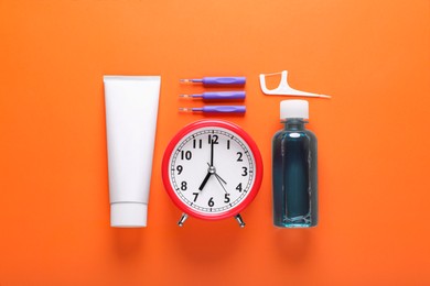 Photo of Dental floss, toothpaste and mouthwash on orange background, flat lay