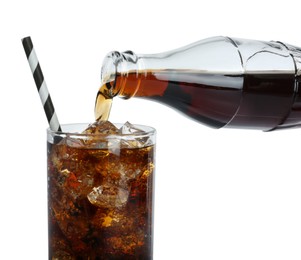 Photo of Pouring cola from bottle into glass with ice cubes on white background, closeup. Refreshing soda water