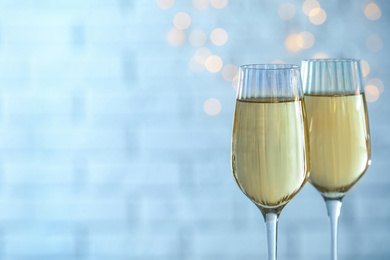 Photo of Glasses of champagne against blurred lights. Space for text