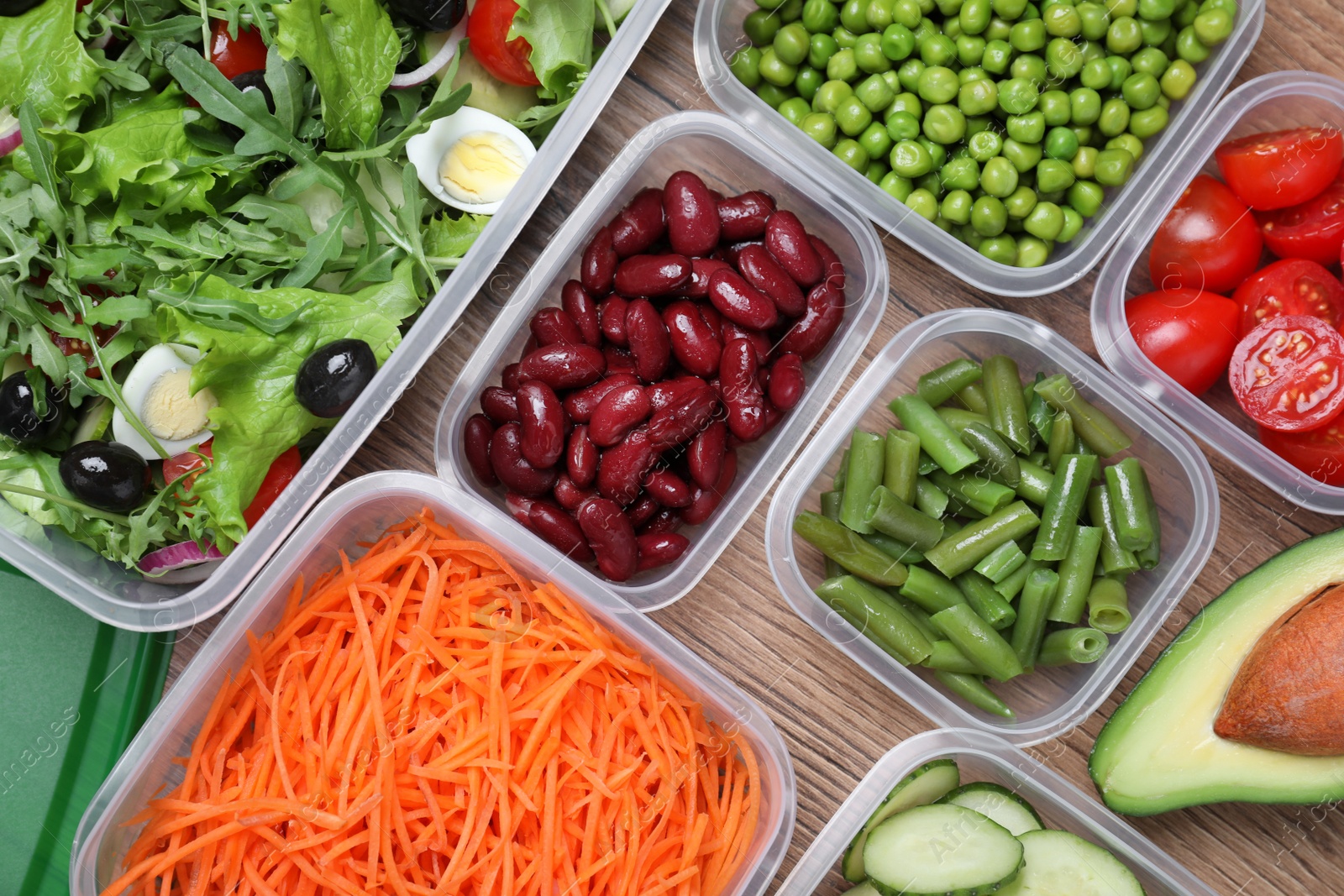 Photo of Set of plastic containers with fresh food on wooden  table, flat lay