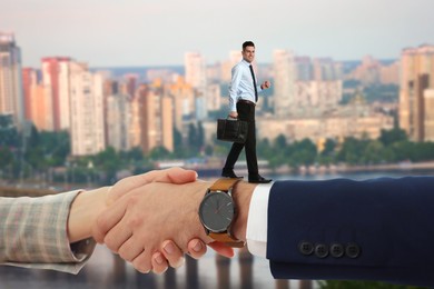 Image of Support, deal or partnership concept. People shaking hands against blurred cityscape, closeup. Businessman using their handshake as bridge to walk forward