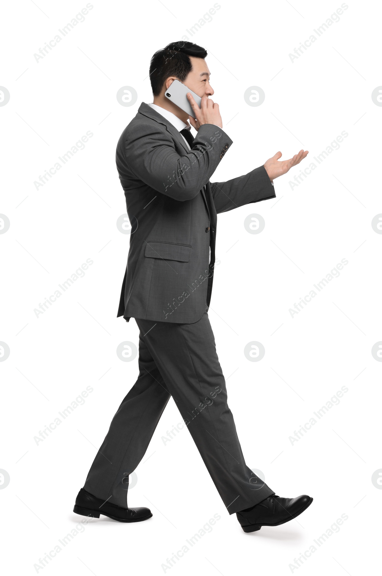 Photo of Businessman in suit talking on phone against white background