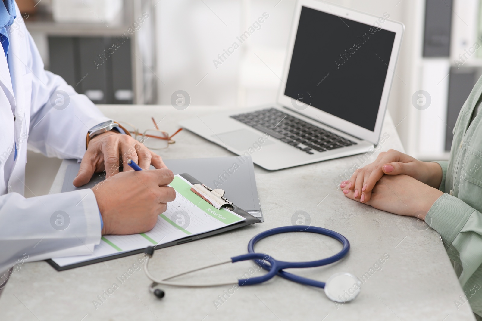 Photo of Doctor filling patient's medical card in clinic, closeup