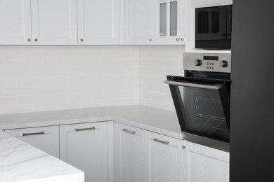 Photo of Modern oven and microwave in white clean kitchen