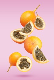 Image of Delicious ripe granadillas falling on violet background