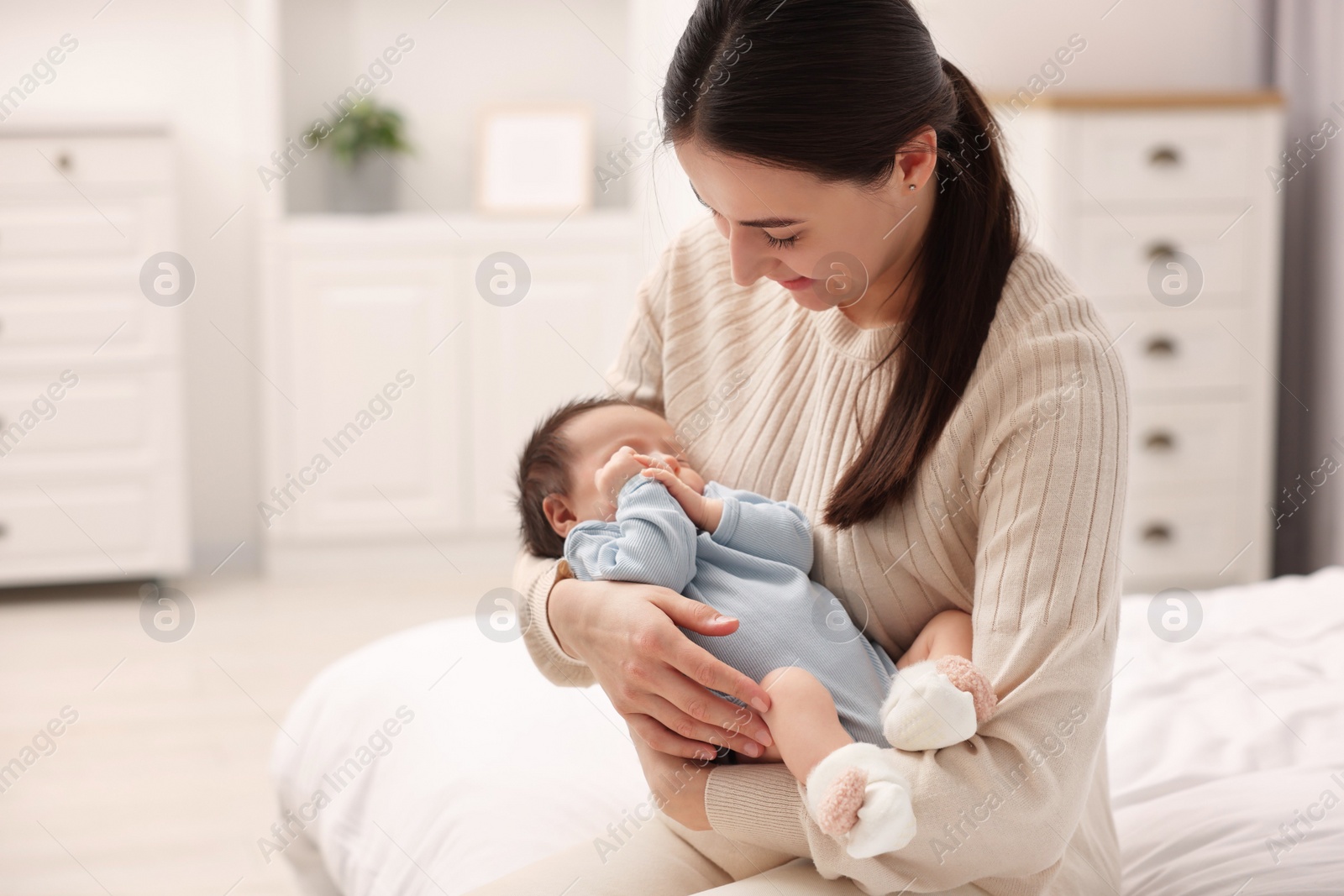 Photo of Mother with her sleeping newborn baby on bed at home, space for text