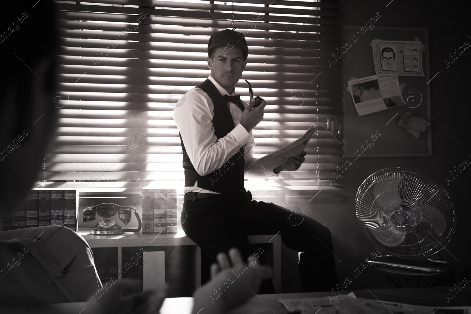Photo of Old fashioned detective working with client in office. Black and white effect