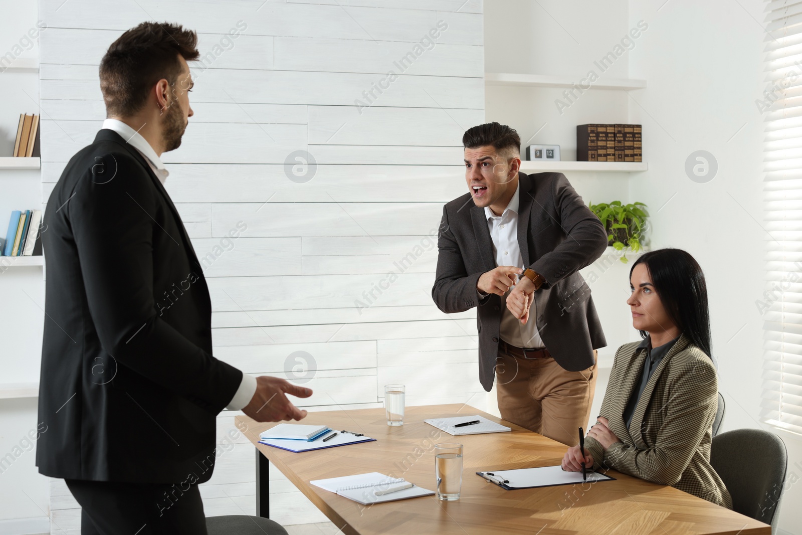 Photo of Businessman scolding employee for being late on meeting in office