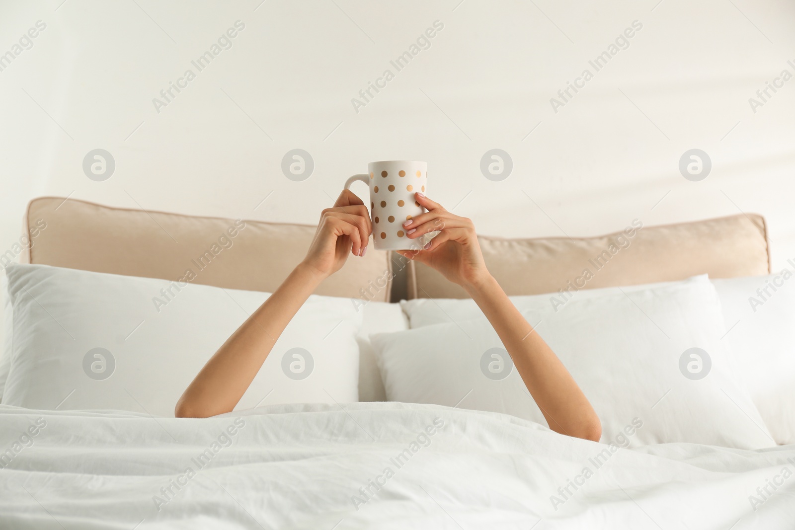 Photo of Woman with cup of coffee in bed, closeup. Lazy morning