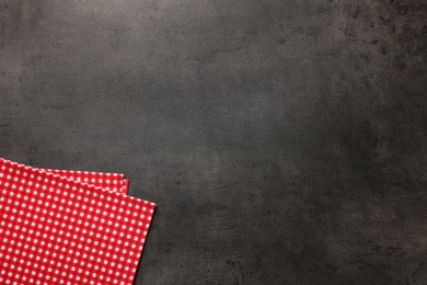 Checkered tablecloth on grey background, top view. Space for text