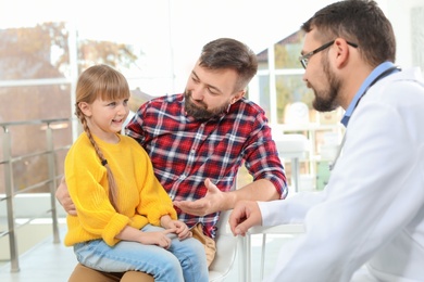 Little girl with father visiting children's doctor in hospital