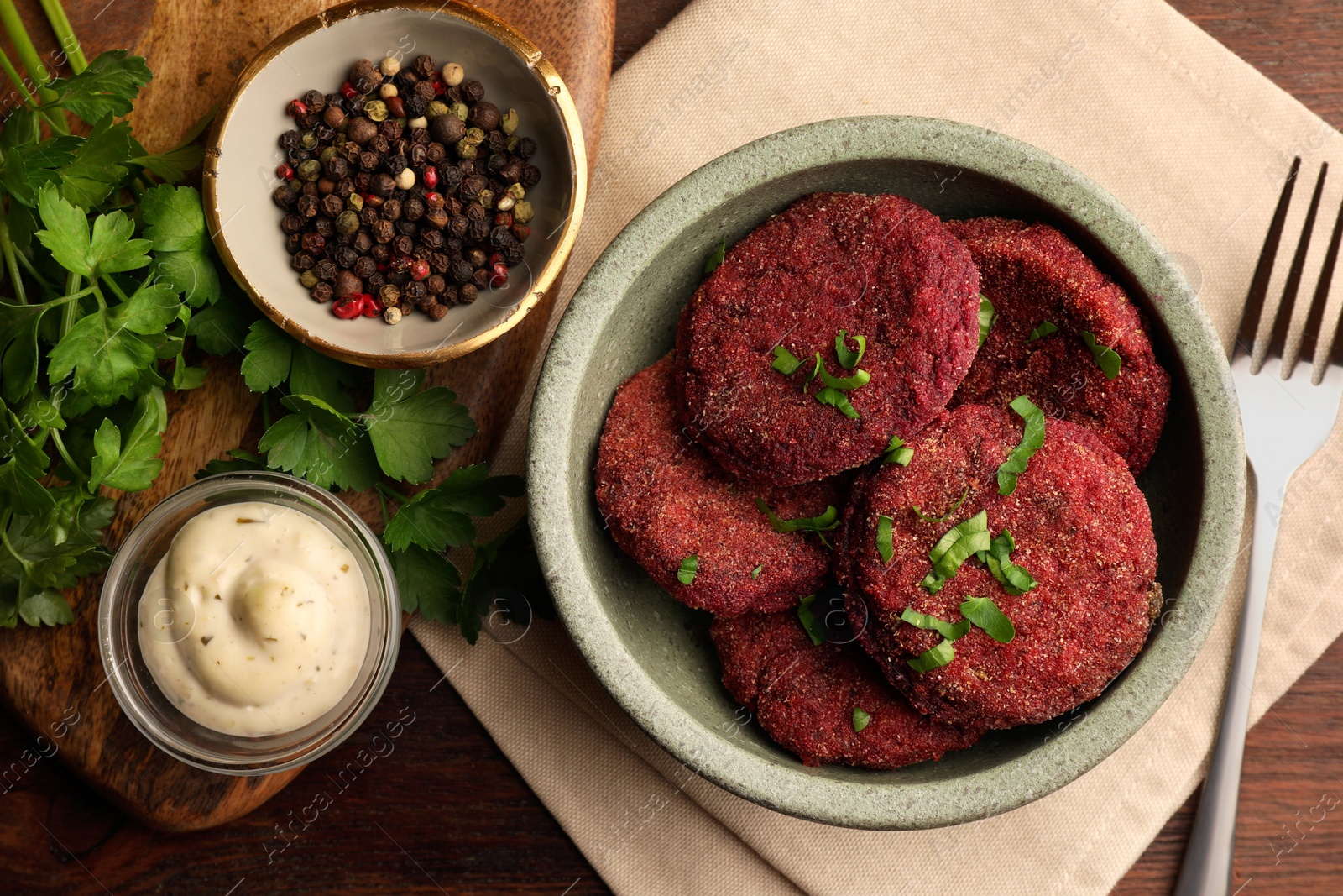 Photo of Tasty vegan cutlets with sauce and ingredients on wooden table, flat lay