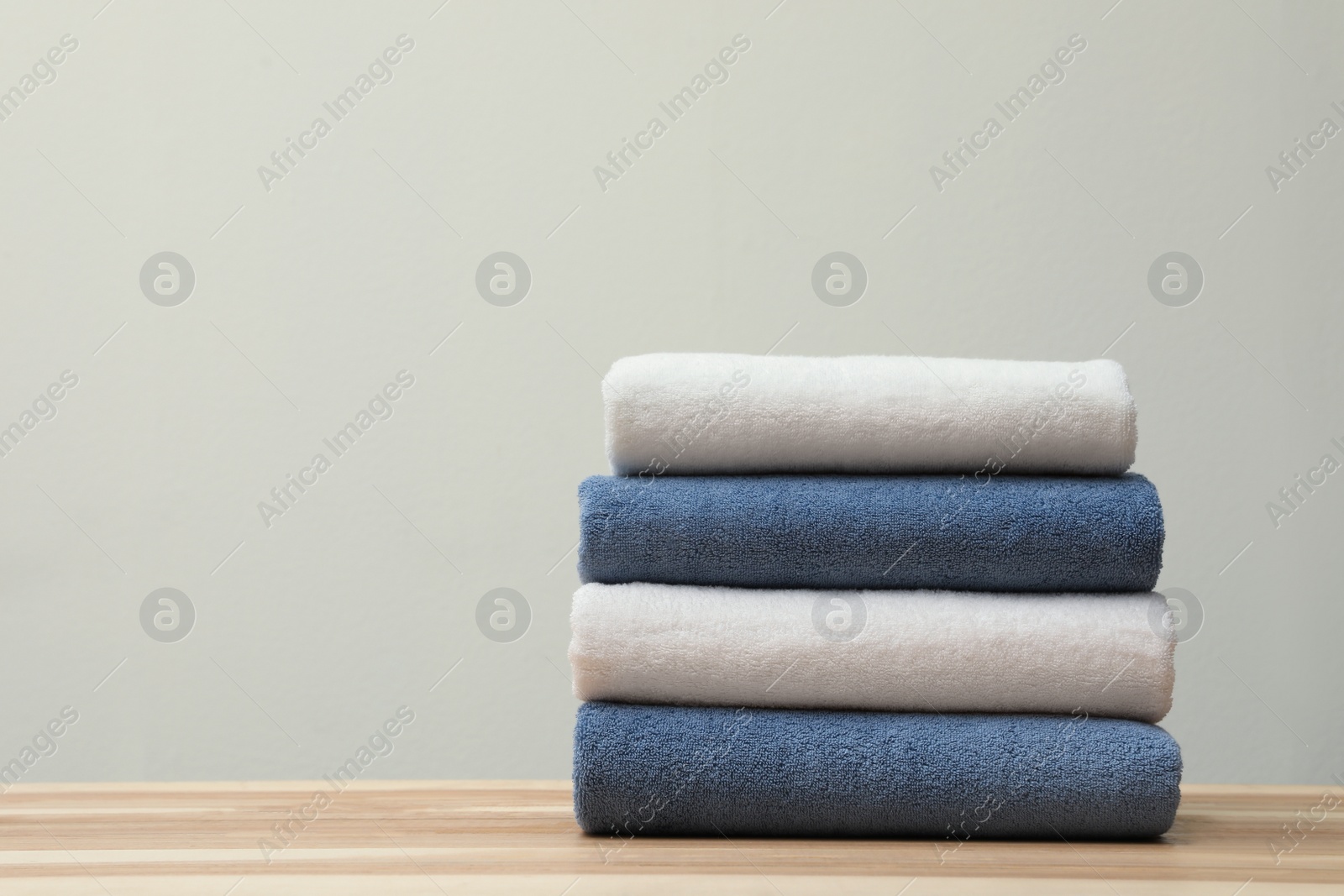 Photo of Stack of fresh towels on table. Space for text