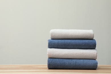 Stack of fresh towels on table. Space for text