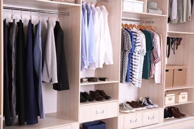 Photo of Large wardrobe with different clothes and shoes