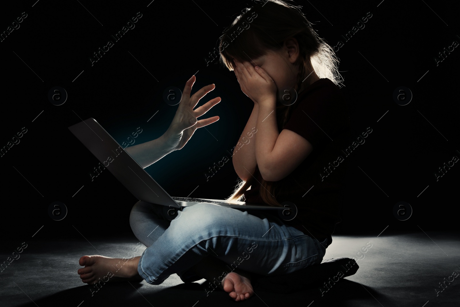 Photo of Stranger reaching frightened little child with laptop on dark background. Cyber danger