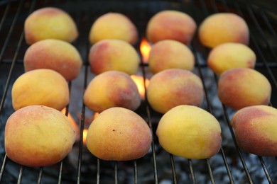 Modern grill with tasty juicy peaches, closeup