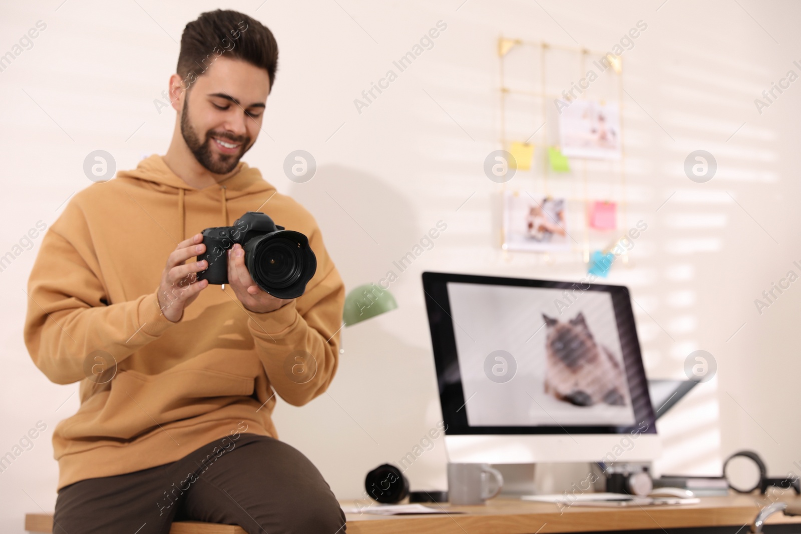 Photo of Professional photographer with camera working in light modern office