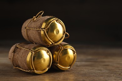 Corks of sparkling wine and muselet caps on wooden table, closeup. Space for text