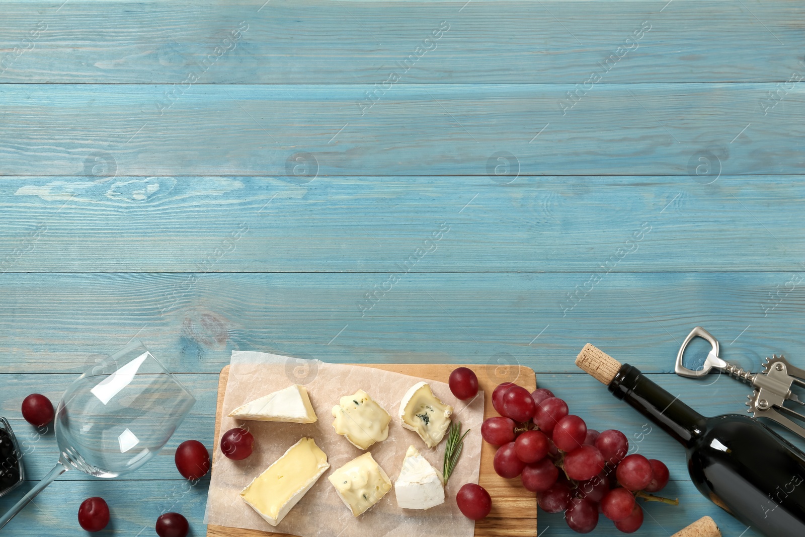 Photo of Flat lay composition with red wine and snacks on turquoise wooden table, space for text