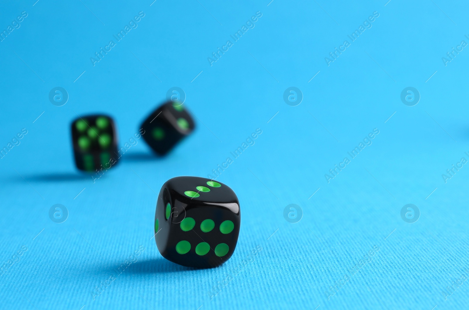 Photo of Many black game dices on light blue background
