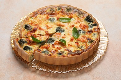 Photo of Delicious homemade quiche with salmon and broccoli on beige table