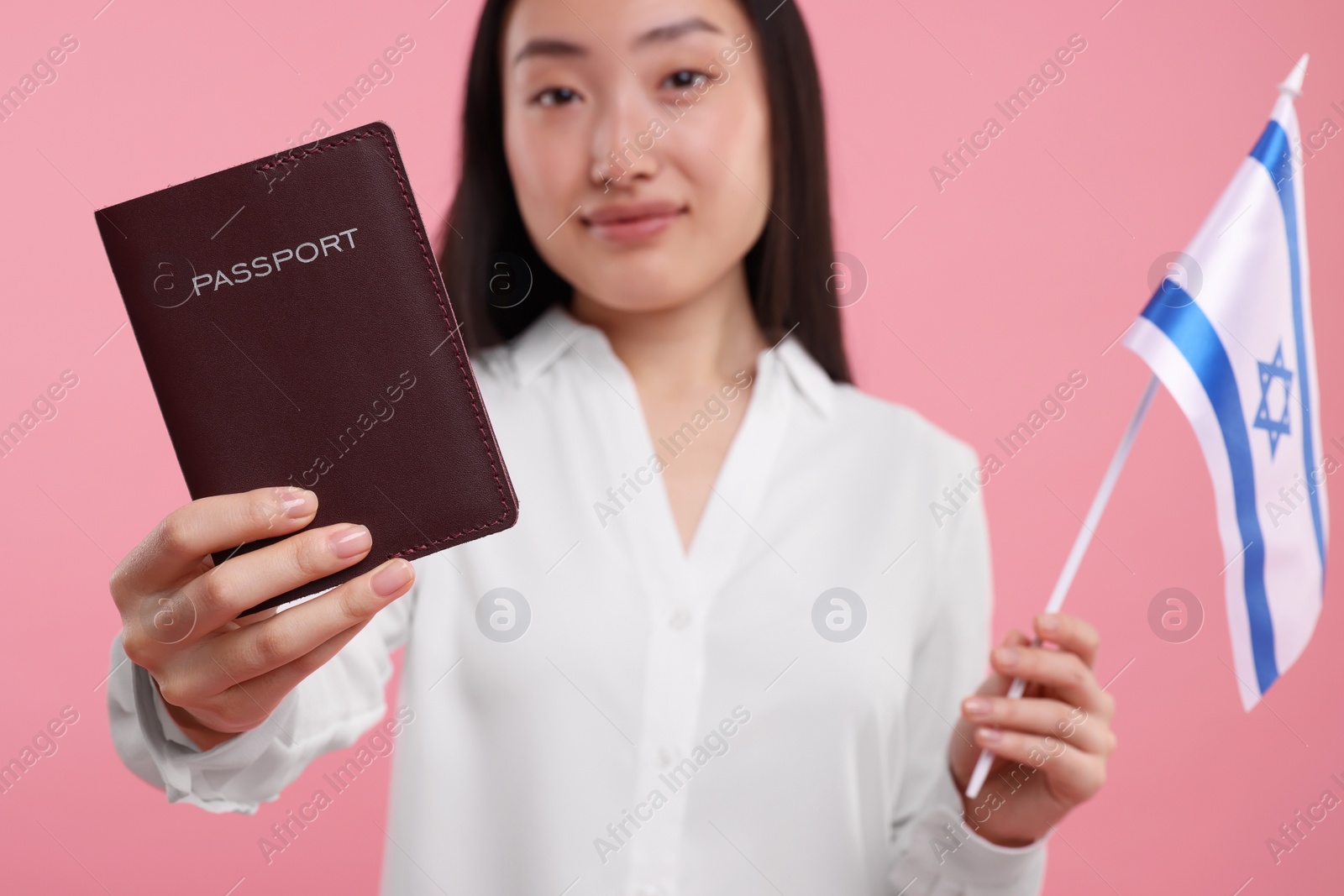 Photo of Immigration to Israel. Woman with passport and flag on pink background, selective focus