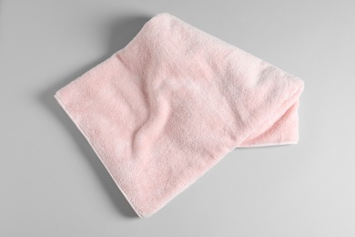 Photo of Soft folded towel on light background, top view