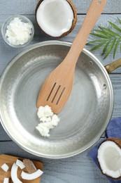 Photo of Flat lay composition with frying pan and organic coconut cooking oil on grey wooden table