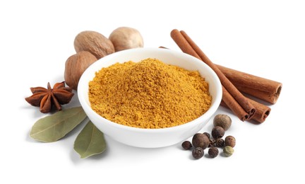 Photo of Dry curry powder in bowl surrounded by other spices isolated on white
