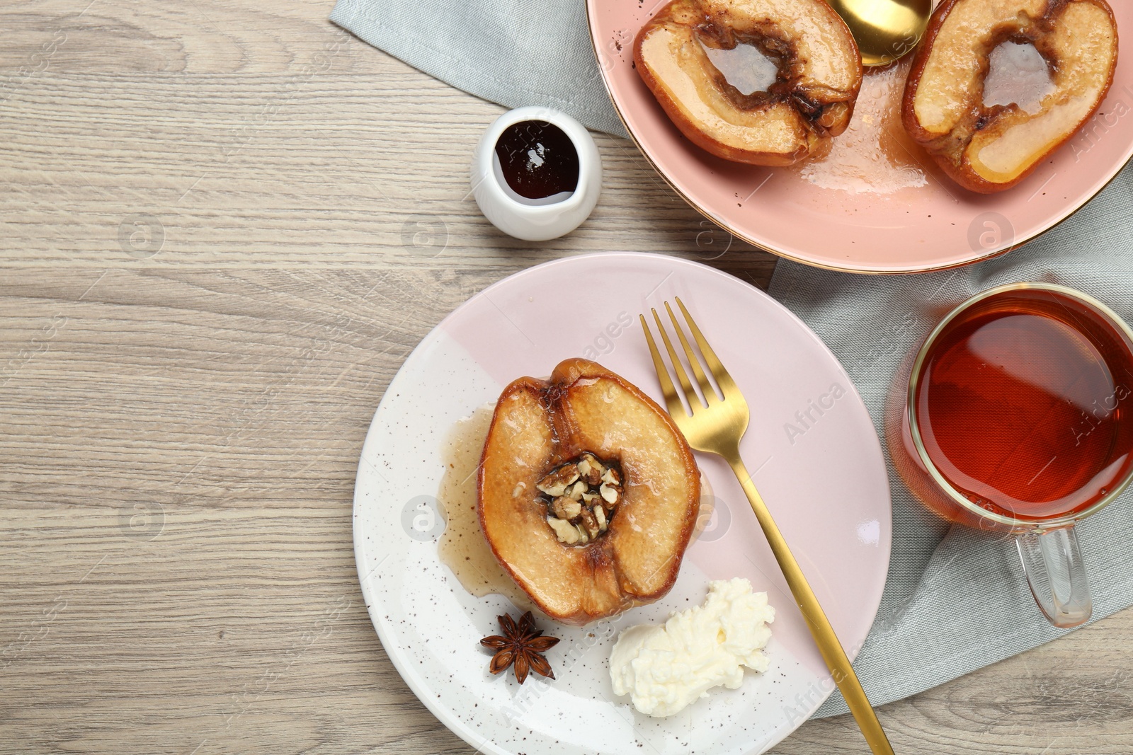 Photo of Delicious quinces baked with honey and walnuts on wooden table, flat lay. Space for text