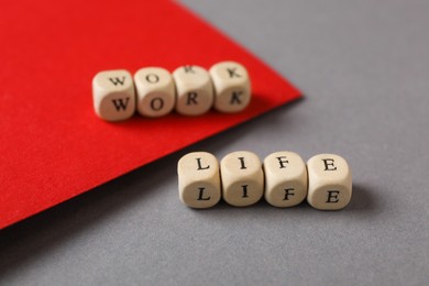 Photo of Words Work, Life made with wooden cubes on grey table. Balance concept