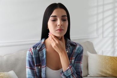 Photo of Young woman doing thyroid self examination at home