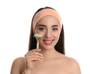 Woman using natural jade face roller on white background