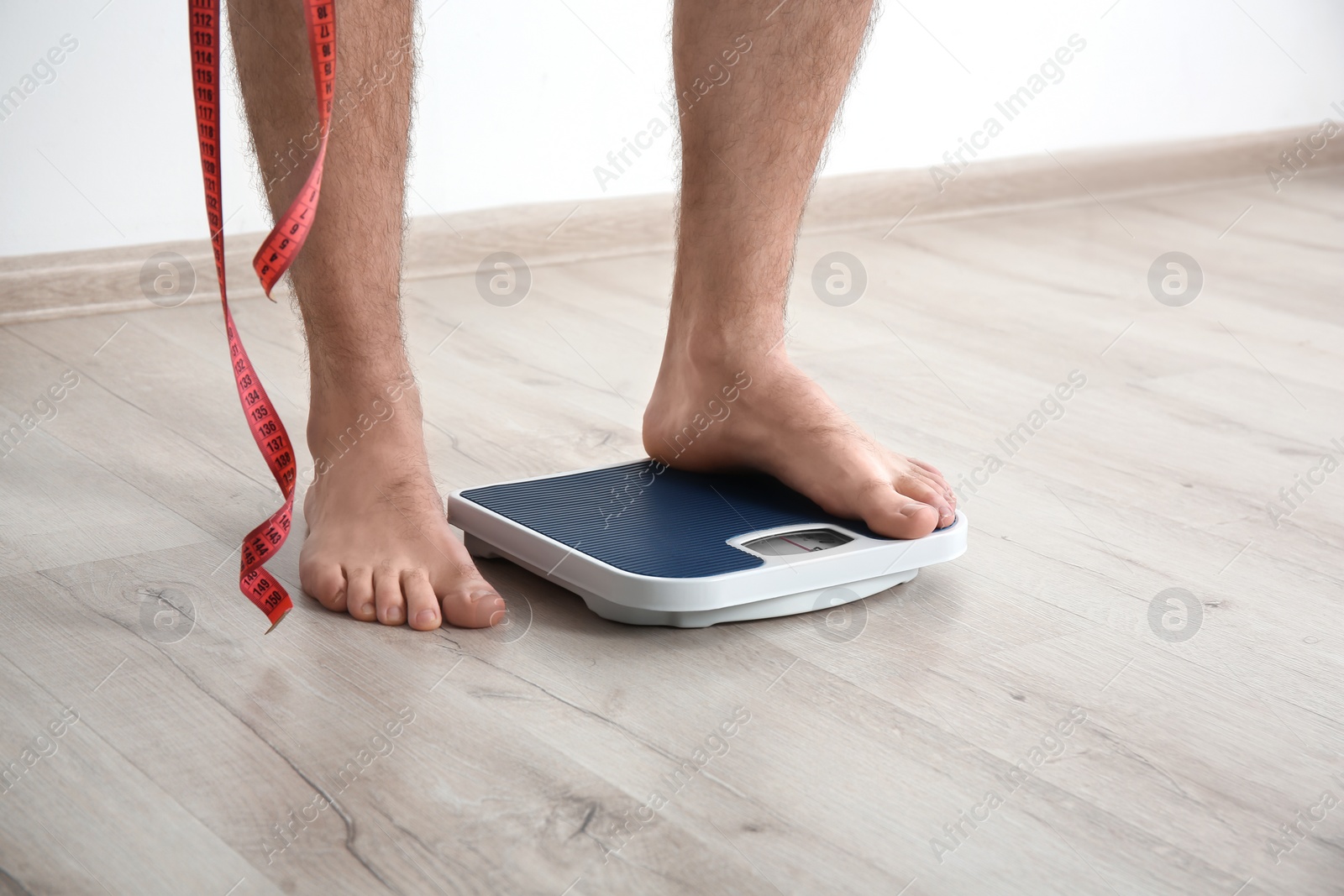 Photo of Overweight man measuring his weight indoors