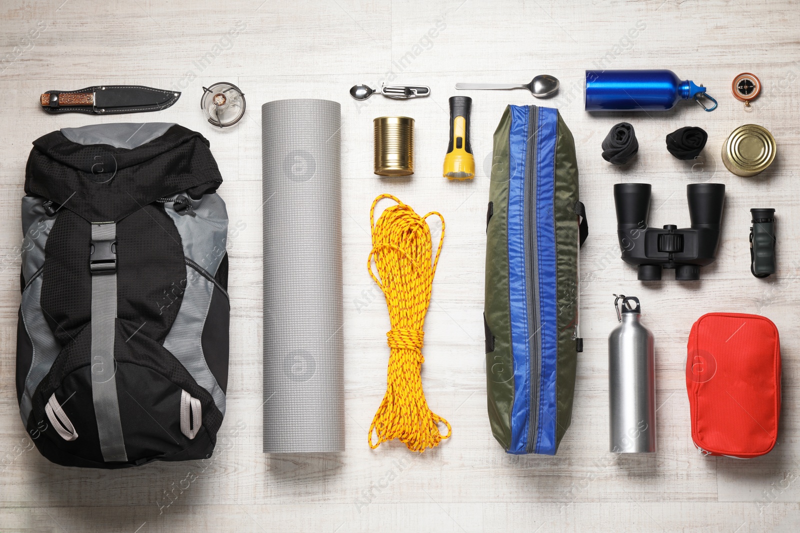 Photo of Flat lay composition with different camping equipment on wooden background