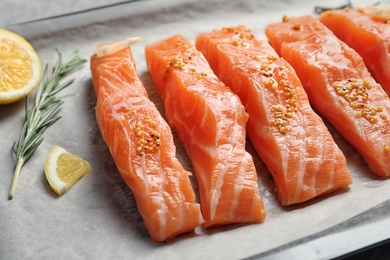 Photo of Fresh salmon with mustard on parchment, closeup