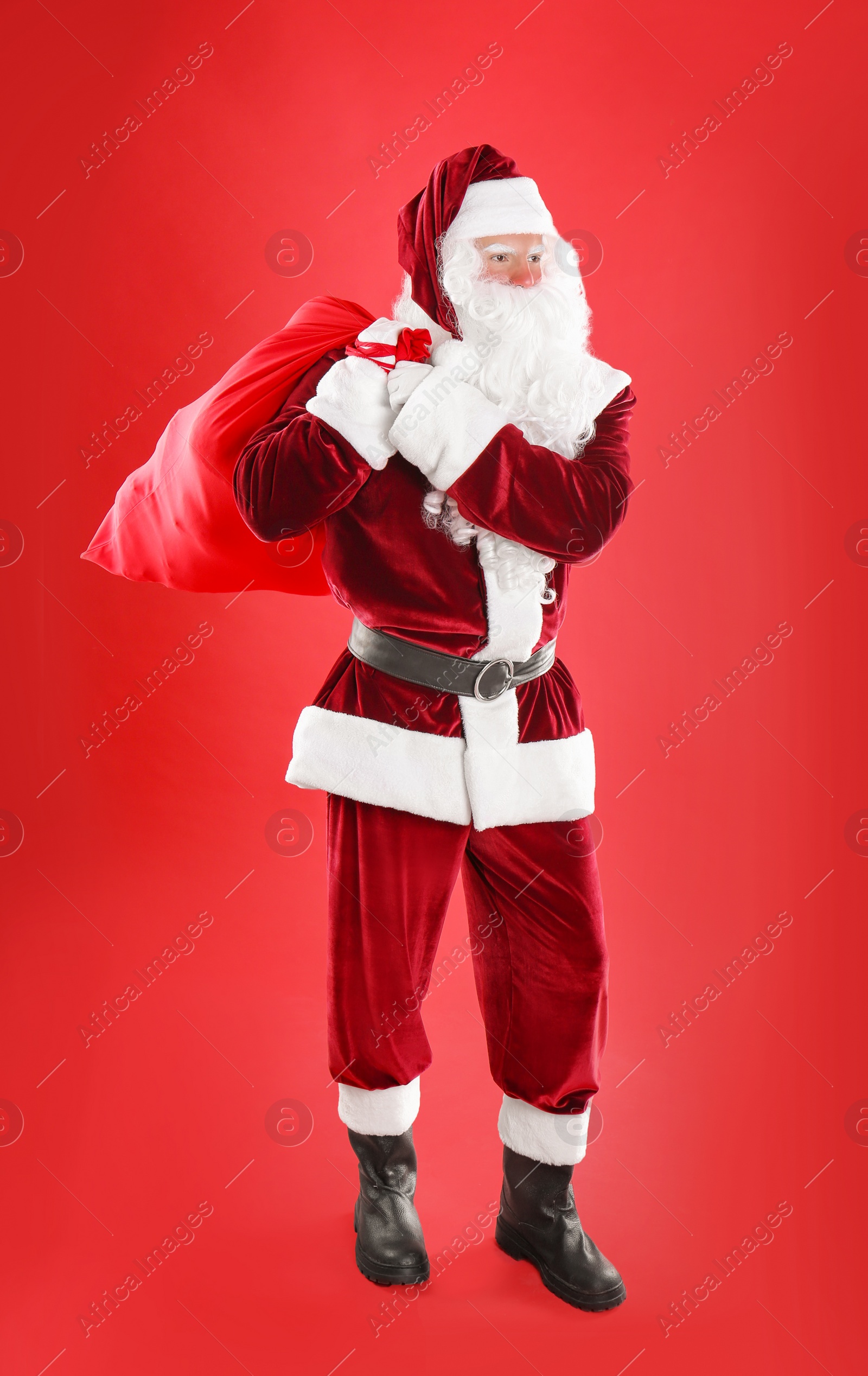 Photo of Santa Claus with sack on red background